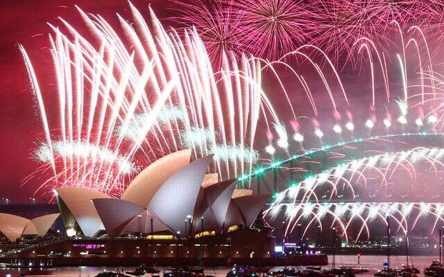 New Year's Eve fireworks light up the sky over the Sydney Opera House (front) and Harbour Bridge during the fireworks display in Sydney on January 1, 2023. (David Gray/AFP)