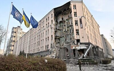 A serviceman stands at the bottom of a hotel, partially destroyed by a Russian strike, in the center of the Ukrainian capital, Kyiv on December 31, 2022 (Sergei Supinsky/AFP)