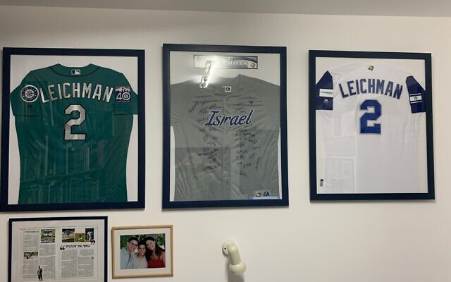 Various jerseys from Alon Leichman’s baseball career are displayed on the wall of his family’s home at Kibbutz Gezer, Israel. (Elli Wohlgelernter/ JTA)