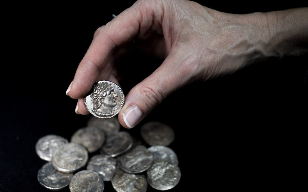 2,200-year-old silver coins that were discovered in a wooden box inside a cave in Wadi Muraba‘at near the Dead Sea. (Shai Halevy, Israel Antiquities Authority)