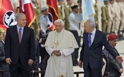Pope Benedict XVI stands with then-president Shimon Peres, right, and Prime Minister Benjamin Netanyahu after arriving at an official welcoming ceremony at Ben Gurion Airport in Tel Aviv, Israel, May 11, 2009. (AP Photo/Kevin Frayer, file)