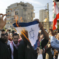 A few dozen people demonstrate and chant slogans as they burn a representation of an Israeli flag during a protest near the U.S. embassy in Aukar, northeast of Beirut, Lebanon, Sunday, November 24, 2019. (AP/Bilal Hussein)