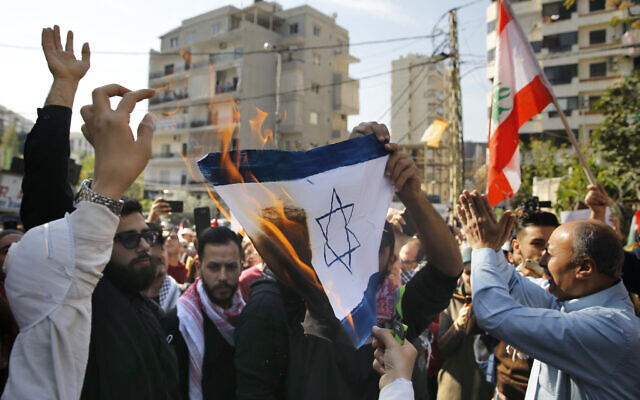 A few dozen people demonstrate and chant slogans as they burn a representation of an Israeli flag during a protest near the U.S. embassy in Aukar, northeast of Beirut, Lebanon, Sunday, November 24, 2019. (AP/Bilal Hussein)