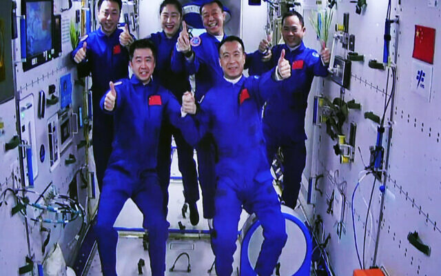 The Shenzhou-15 and Shenzhou-14 crew take a group picture with their thumbs up after a historic gathering in space on Nov. 30, 2022. (Guo Zhongzheng/Xinhua News Agency via AP)
