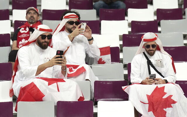 FILE - Canadian fans cheer ahead of F World Cup soccer action between Canada and Croatia at the Khalifa International Stadium in Al Rayyan, Qatar on Sunday, Nov. 27, 2022.  At a World Cup that has become a political lightning rod, it comes as no surprise that soccer fans’ sartorial style has sparked controversy. At the first World Cup in the Middle East, fans from around the world have refashioned traditional Gulf Arab headdresses and thobes. (Nathan Denette/The Canadian Press via AP, File)