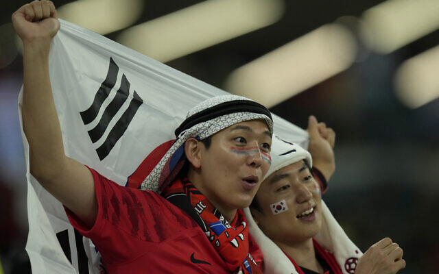 FILE - Soccer fans await the start of the World Cup group H soccer match between South Korea and Portugal, at the Education City Stadium in Al Rayyan , Qatar, Friday, Dec. 2, 2022.  At a World Cup that has become a political lightning rod, it comes as no surprise that soccer fans’ sartorial style has sparked controversy. At the first World Cup in the Middle East, fans from around the world have refashioned traditional Gulf Arab headdresses and thobes. (AP Photo/Francisco Seco, File)