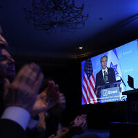 Audience members applaud as US Secretary of State Antony Blinken is seen on a large screen as he speaks at the J Street National Conference at the Omni Shoreham Hotel in Washington, Dec. 4, 2022. (AP Photo/Carolyn Kaster)