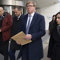 Rodney Dixon, lawyer for Al Jazeera, center with letter, and Lina Abu Akleh, niece of fatally shot Al Jazeera journalist Shireen Abu Akleh, right, walk to to the International Criminal Court in The Hague, Netherlands, to present a letter requesting a formal investigation into the killing, December 6, 2022. (Peter Dejong/AP)