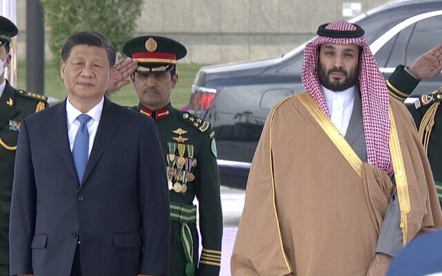 In this image taken from footage by Saudi State TV, Chinese President Xi Jinping, left, listens to the Chinese national anthem next to Saudi Crown Prince and Prime Minister Mohammed bin Salman in Riyadh, Saudi Arabia, Dec. 8, 2022. (Saudi Press Agency via AP)