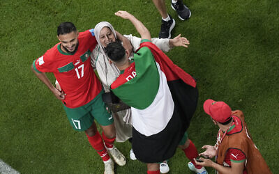 Morocco's Achraf Daria, with a Palestine flag, celebrates next to his teammate Sofiane Boufa after the World Cup quarterfinal soccer match between Morocco and Portugal, at Al Thumama Stadium in Doha, Qatar, December 10, 2022. Morocco won 1-0.(AP Photo/Thanassis Stavrakis)