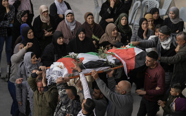 Palestinians carry the body of Jana Zakarna, 16, during her funeral in the West Bank city of Jenin, December 12, 2022. (AP Photo/Majdi Mohammed)