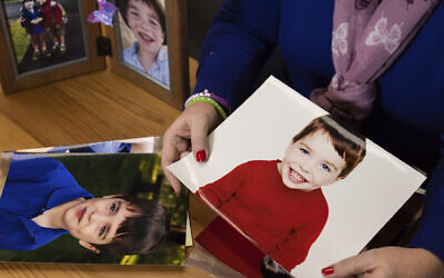 Co-founder and CEO of Sandy Hook Promise Foundation Nicole Hockley shows photos of her son, Dylan, in her office, in Newtown, Connecticut, December 5, 2022. (Julia Nikhinson/AP)