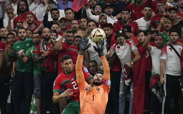 France's goalkeeper Hugo Lloris and Morocco's Achraf Hakimi challenge for the ball in front of Morocco's supporters during the World Cup semifinal soccer match between France and Morocco at the Al Bayt Stadium in Al Khor, Qatar, Wednesday, Dec. 14, 2022. (AP Photo/Martin Meissner)