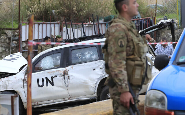 Lebanese soldiers stand next to a damaged UN peacekeeper vehicle at the scene where a UN peacekeeper convoy came under gunfire in the al-Aqbiya village, south Lebanon, December 15, 2022. (AP Photo/Mohammed Zaatari)