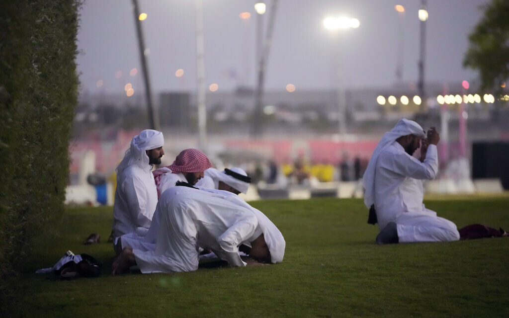 Men pray before the World Cup Group A soccer match between Qatar and Ecuador at the Al Bayt Stadium in Doha, November 20, 2022. (AP Photo)