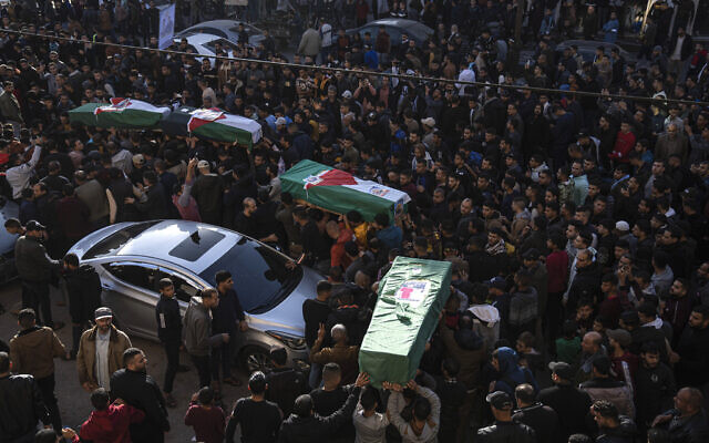 Palestinians carry the bodies of four Palestinian migrants who died off the Tunisian coast, in Rafah in the southern Gaza Strip, December 18, 2022. (AP/ Fatima Shbair)