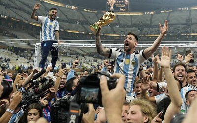 Argentina's Lionel Messi celebrates with the trophy in front of the fans after winning the World Cup final soccer match between Argentina and France at the Lusail Stadium in Lusail, Qatar, Sunday, Dec. 18, 2022. Argentina won 4-2 in a penalty shootout after the match ended tied 3-3. (AP Photo/Martin Meissner)