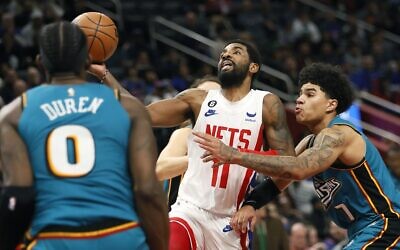 Brooklyn Nets guard Kyrie Irving (11) goes to the basket against Detroit Pistons center Jalen Duren (0) and guard Killian Hayes (7) during the second half of an NBA basketball game, in Detroit, December 18, 2022. (Duane Burleson/AP)