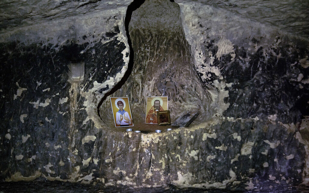 Religious icons left by prior visitors are seen inside a 2,000-year-old Second Temple-Period burial cave designated the Salome Cave that was recently uncovered in the Lachish Forest in Israel, December 20, 2022. (AP Photo/ Maya Alleruzzo)