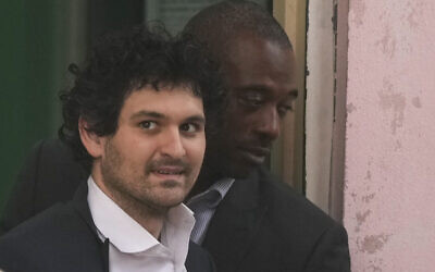FTX founder Sam Bankman-Fried, is escorted from the Magistrate Court in Nassau, Bahamas, December 21, 2022, after agreeing to be extradited to the US. (AP Photo/Rebecca Blackwell)