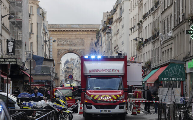 A fire brigade ambulance is see behind police tape where a shooting took place in Paris, France, December 23, 2022.  (AP Photo/Lewis Joly)