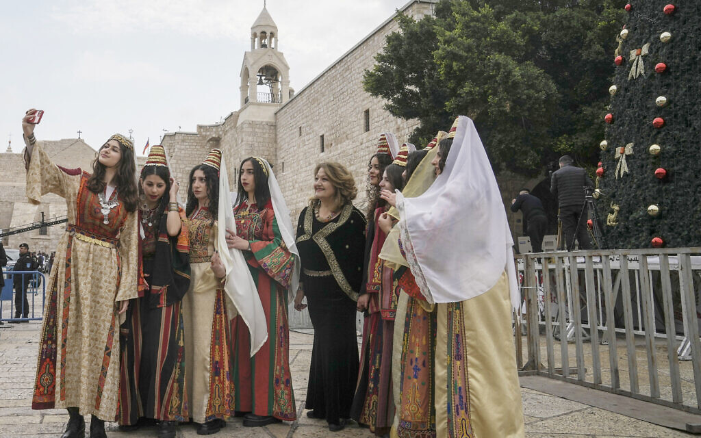 Women pose for a photo as they visit the Church of the Nativity, traditionally believed to be the birthplace of Jesus Christ, in the town of Bethlehem, December 24, 2022. (AP Photo/Mahmoud Illean)