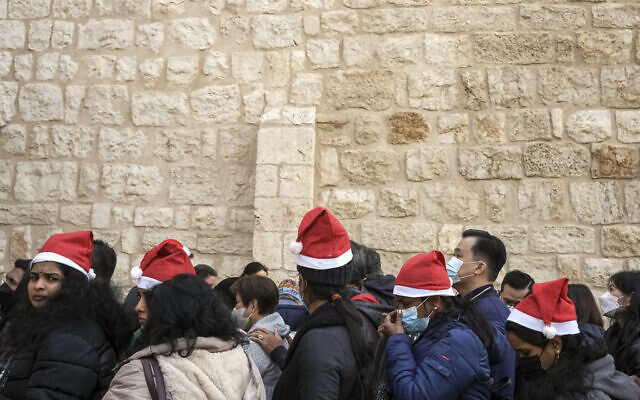 Tourists queue to enter the Church of the Nativity, traditionally believed to be the birthplace of Jesus Christ, in the West Bank town of Bethlehem, December 24, 2022. (AP Photo/Maya Alleruzzo)