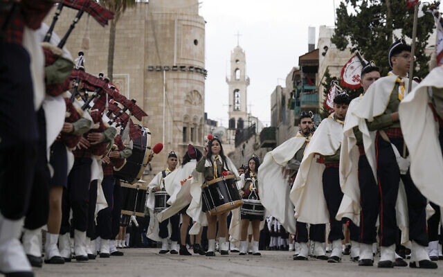 Palestinian scouts march during Christmas parade towards to the Church of the Nativity, traditionally believed to be the birthplace of Jesus Christ, in the West Bank town of Bethlehem, December 24, 2022. (AP Photo/Majdi Mohammed)