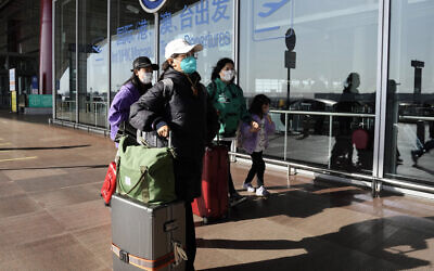File: Passengers wearing masks walk through Beijing Capital Airport terminal, in China, December 13, 2022. (AP/Ng Han Guan)