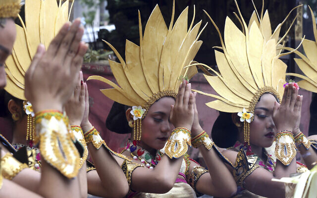 Women dancers pray before their perform during culture parade to bid farewell to 2022 and welcoming 2023 in Bali, Indonesia on December 31, 2022. (AP Photo/Firdia Lisnawati)