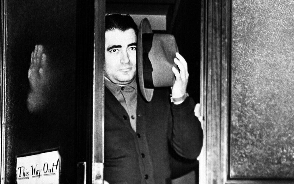 Charles 'The Bug' Workman attempts to shield his face with his hat as he leaves the district attorney's office in Brooklyn, New York, March 30, 1941, to be booked as a fugitive from justice in a nearby police station. Workman was indicted in Newark, New Jersey, for the murder of Dutch Schultz there in 1935. (AP Photo)