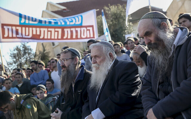 Rabbi Chaim Druckman, center-right, attends a demonstration against the demolition of nine homes in the Ofra settlement in the northern West Bank on February 5, 2017. (Noam Revkin Fenton/ Flash90/ File)