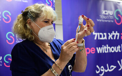 A healthcare worker prepares a COVID vaccine dose at the Sheba Medical Center on January 5, 2022. (Avshalom Sassoni/Flash90)