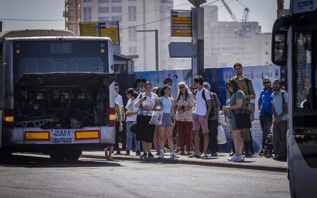 Passengers wait for a bus at the entrance to Jerusalem on August 1, 2022. (Olivier Fitoussi/Flash90)