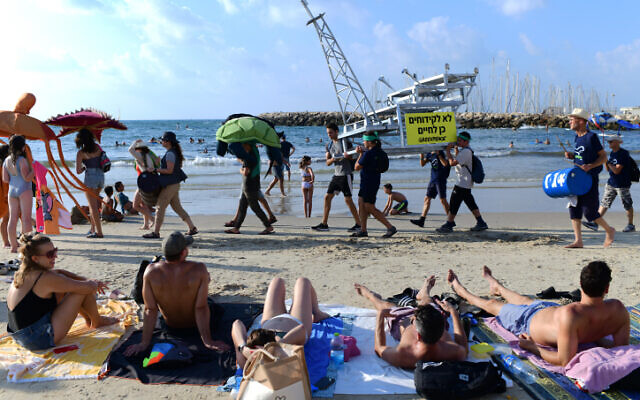 Climate activists protest against offshore drilling, at the beach in Tel Aviv, on August 13, 2022. (Tomer Neuberg/Flash90)