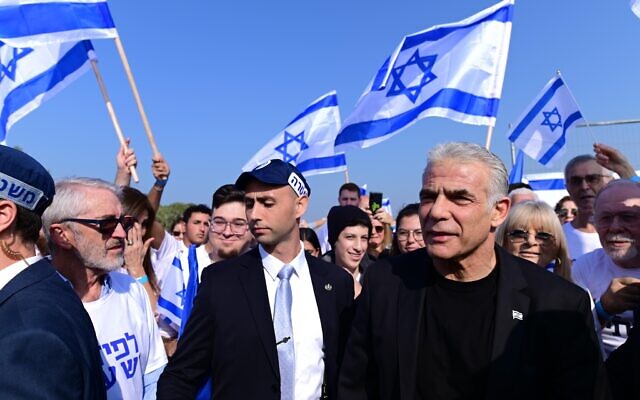 Then-prime minister Yair Lapid and Yesh Atid activists protest against Benjamin Netanyahu and his expected government, in Tel Aviv, December 9, 2022. (Tomer Neuberg/Flash90)