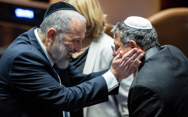 Shas leader Aryeh Deri (L) embraces Otzma Yehudit leader Itamar Ben Gvir during a Knesset session at which a new speaker was elected, December 13, 2022. (Yonatan Sindel/Flash90)