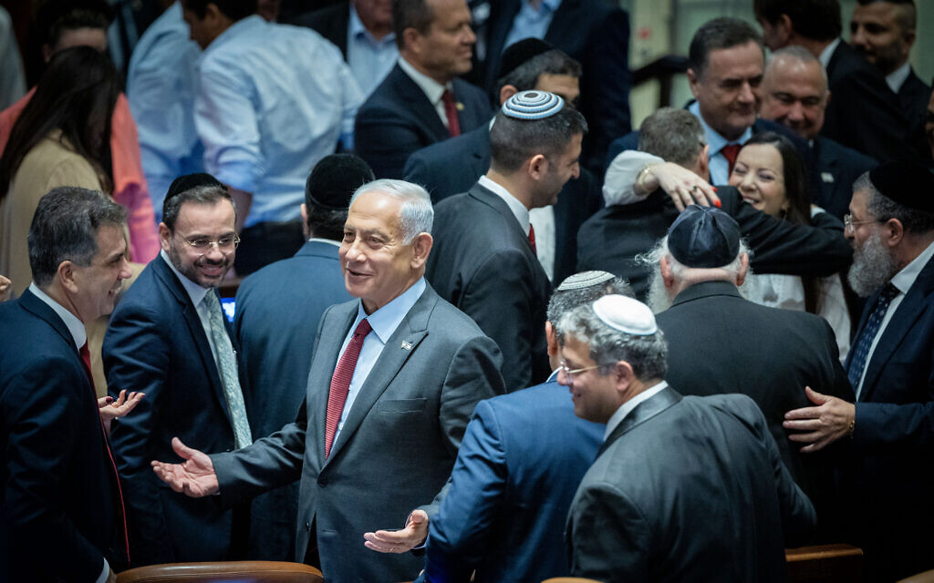 Likud leader Benjamin Netanyahu is surrounded by MKs after a vote for the new Knesset speaker on December 13, 2022. At bottom right is Otzma Yehudit leader Itamar Ben Gvir. (Yonatan Sindel/Flash90)