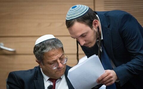 Otzma Yehudit party chief Itamar Ben Gvir (L) speaks with his chief of staff Chanamel Dorfman during a Knesset special committee to discuss his proposed Police Ordinance changes, December 18, 2022. (Yonatan Sindel/Flash90)