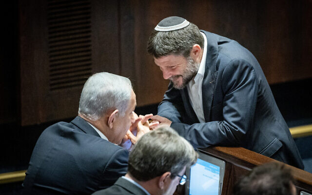 Religious Zionist party head MK Bezalel Smotrich (right) speaks with Likud leader Benjamin Netanyahu during a vote in the Knesset on December 20, 2022. (Yonatan Sindel/Flash90)