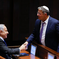 Incoming National Security Minister Itamar Ben Gvir shakes hands with incoming Prime Minister Benjamin Netanyahu in the Knesset after a vote to expand Ben Gvir's ministerial powers, December 28, 2022. (Olivier Fitoussi/Flash90)