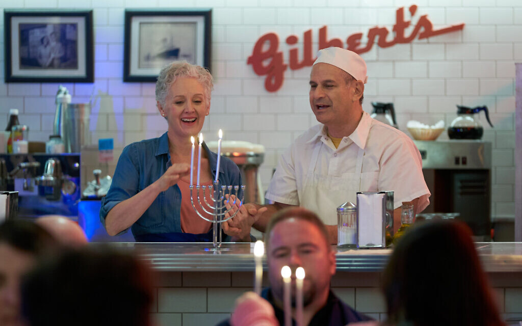 The Spiegelmans - played by Lisa Horner and David Eisner - behind the counter at Gilbert's Deli in the film 'Hanukkah on Rye.' (Steven Ackerman/Hallmark Media)