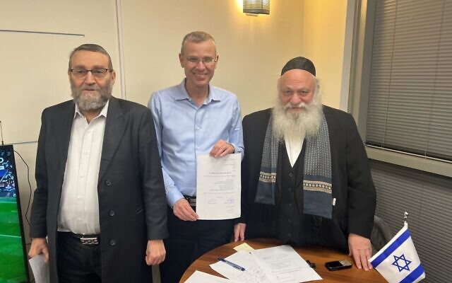 United Torah Judaism MKs Moshe Gafni (left) and Yitzhak Goldknopf (right) sign an interim coalition deal with Likud negotiator Yariv Levin on December 6, 2022. (Courtesy)