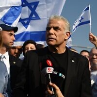Outgoing Prime Minister Yair Lapid, center, addresses Yesh Atid supporters at the KKL Bridge in Tel Aviv, December 9, 2022. (Elad Gutman/Yesh Atid)