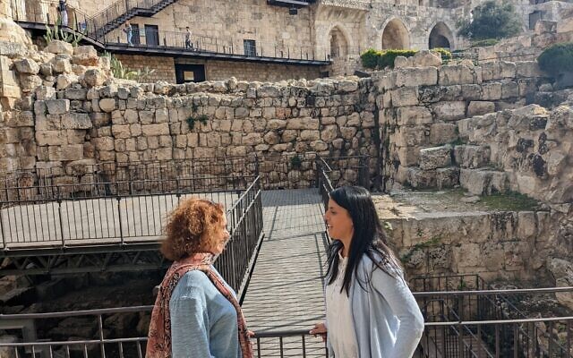 Curator Ravit Ninner-Soriano (left) and archaeologist Reut Kozak in front of the Hasmonean wall built more than 2,000 years ago, at the Tower of David in Jerusalem on December 13, 2022. (Melanie Lidman/Times of Israel)