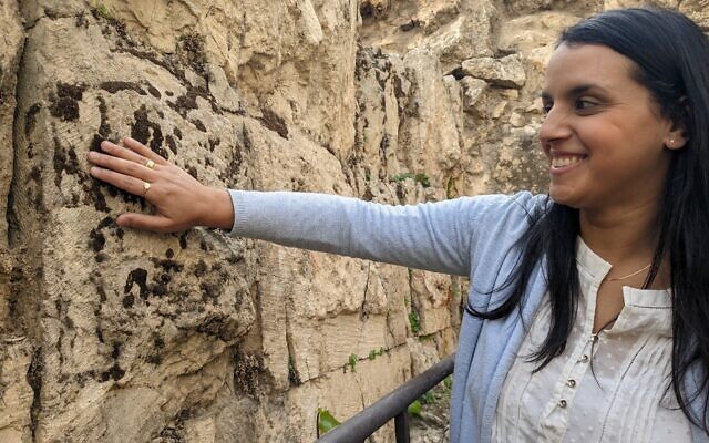 Archaeologist Reut Kozak shows traditional Hasmonean stone carving, which featured a smooth frame and rough-hewn protruding center, and was less refined than the smooth stone blocks of the Herodian period, at the Tower of David in Jerusalem on December 13, 2022. (Melanie Lidman/Times of Israel)