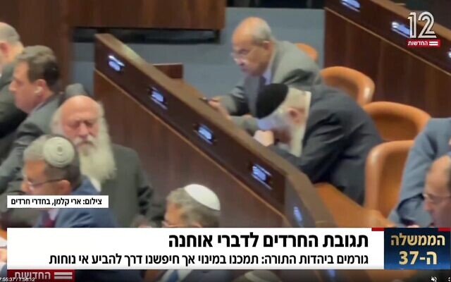 United Torah Judaism MKs Yitzhak Goldknopf and Meir Porush, a minister and deputy minister, respectively, in the new government, avert their gaze as MK Amir Ohana, who is gay, makes his first speech as Knesset speaker, December 29, 2022 (Screenshot from footage by Ari Kalman, Behadrei Haredim, broadcast on Channel 12; used in accordance with clause 27a of the Copyright Law)