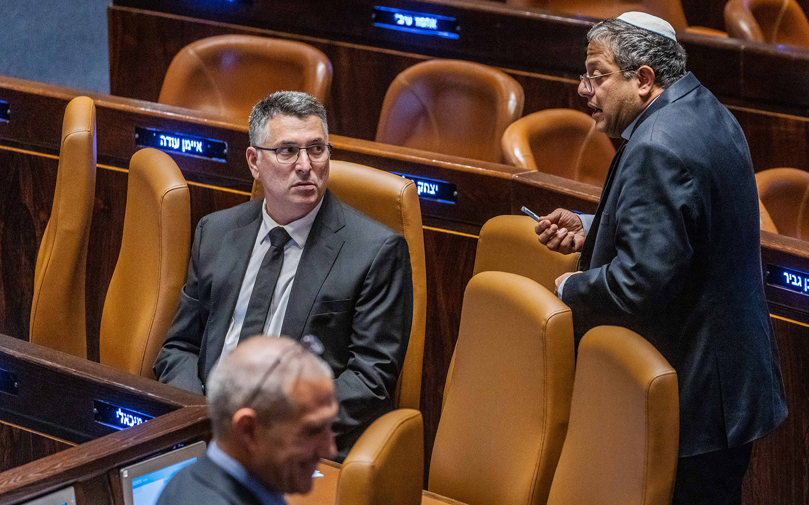 Outgoing Justice Minister Gideon Sa’ar, left, and Otzma Yehudit party leader Itamar Ben Gvir, right, attend a vote during a plenum session at the assembly hall of the Knesset in Jerusalem, on December 15, 2022. (Olivier Fitoussi/Flash90)