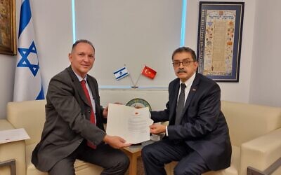 Sakir Ozkan Torunlar (right) presents a copy of his letter of credence to Gil Haskel, the Foreign Ministry's chief of state protocol, December 1, 2022 (Foreign Ministry)