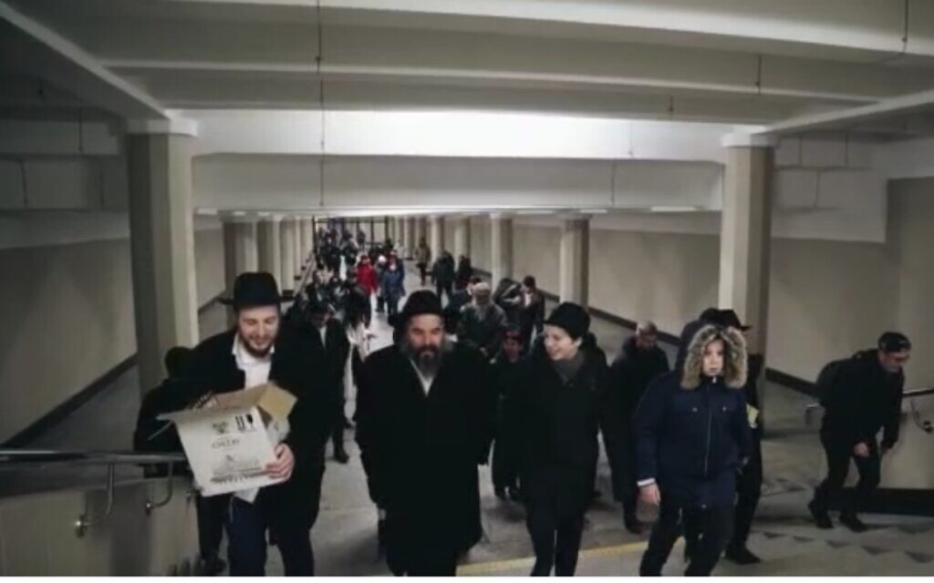 Rabbi Moshe Moskowitz (second from left_ and his children walk through a subway station in Kharkiv, Ukraine, on the first night of Hanukkah, December 18, 2022 (courtesy Kharkiv Choral Synagogue)